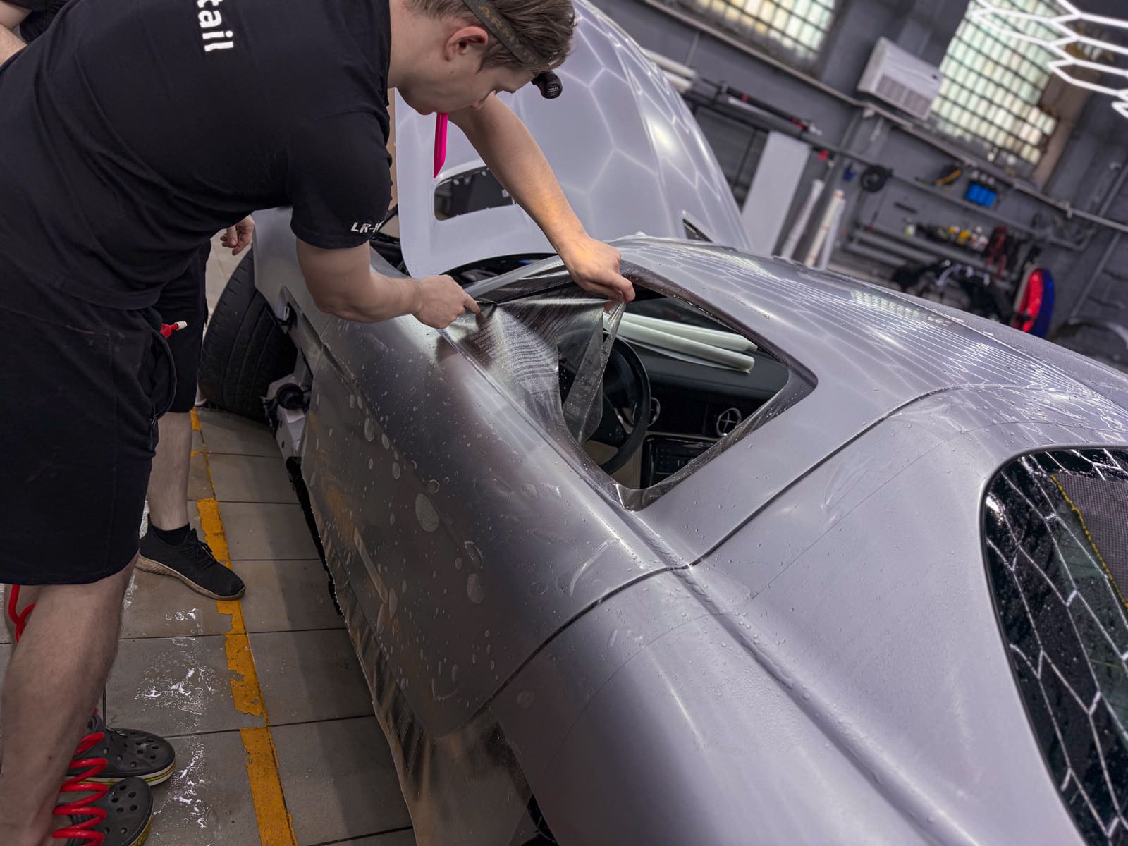 мастер оклеивает сложный кузовной элемент Mercedes-AMG SLS